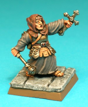 Figure 4, variant A, Cleric with Cross.<br>his Cleric figure wears a plate armour breastplate over his simple robes, and a hooded cowl conceals his helmeted head. He carries the usual stock of adventuring gear, including a backpack, rope, lantern and pouches. In his right hand he holds a studded ball-mace and his left hand holds aloft his holy symbol, a jewelled cross. At some time soon after release of this set, this figure was remodelled for unknown reasons. It is possible that TSR or Citadel reacted to complaints from Christian groups who were not happy to see the cross used on fantasy figures, or perhaps the cross-bearing cleric was difficult to cast accurately. Whatever the reason, this variant was replaced by the version below.