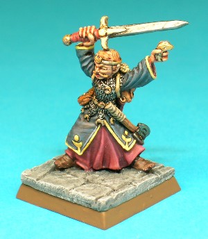 Figure 6, Elf with Sword.<br>This is the first of two Elf Characters in the set. This one wears a long robe under a fine chainmail shirt. He wields a longsword above his head and holds a crescent-moon mystic symbol in his left hand. He also carries a mace, a coil of rope, a sack, a belt pouch and a scabbard for his longsword.